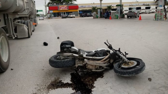 Playa del Carmen.- Por querer esquivar a un vehículo particular, un motociclista termina debajo de un trailer estacionado, sobre el bulevar Playa del Carmen.