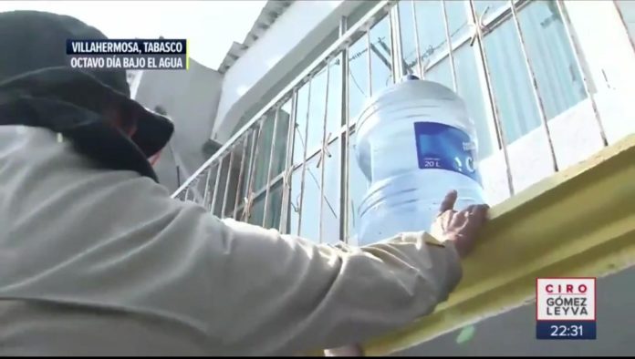 Agentes de la Fiscalía de Tabasco ayudaron a la gente a sacar la mercancía de una tienda para que pudieran tener agua y alimentos