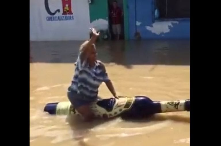 Tabasco: mujer se pasea por calle inundada en botella gigante de tequila y es viral