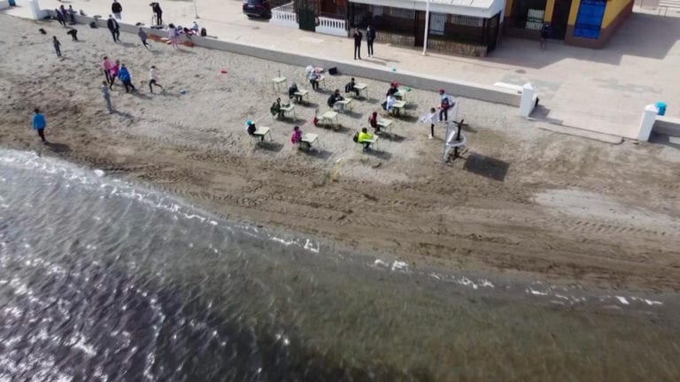 Niños toman clases presenciales en la playa para mantener la sana distancia
