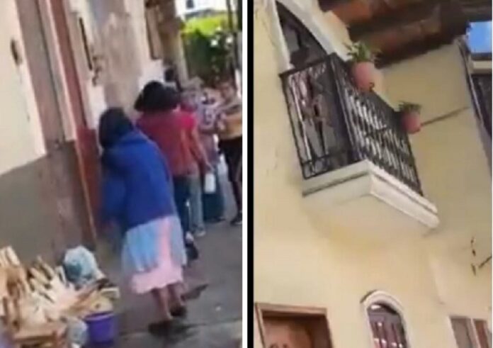 Desde el balcón moja a humilde abuelita que tiene puesto ambulante de artesanías