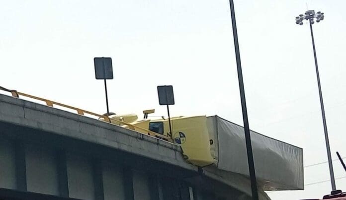 Por un accidente un tráiler se volcó y está a punto de caer al vacío, quedó colgado en un puente sobre la México-Querétaro. Hay un grave caos vial.