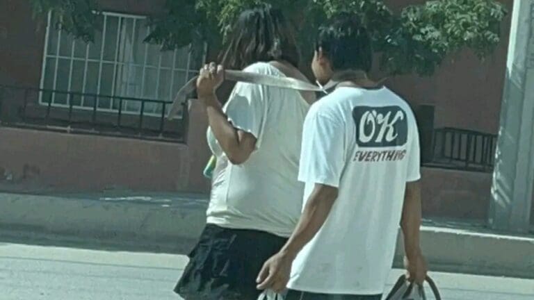VIDEO: Mujer amarra con un cinturón a su pareja y lo pasea sonriente por las calles