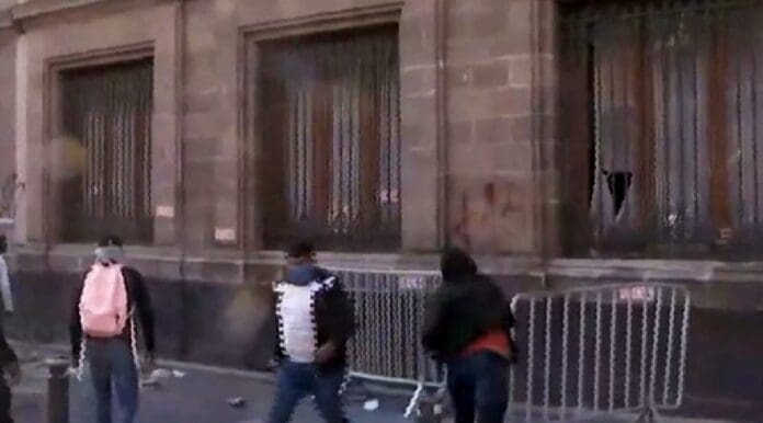 VIDEO: Normalistas irrumpen y derriban puerta de Palacio Nacional durante mañanera de AMLO