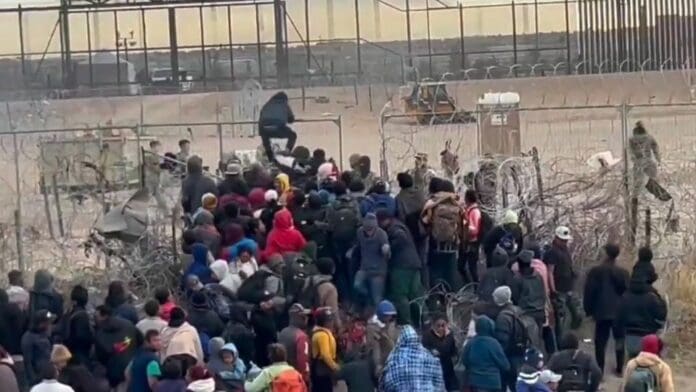 Migrantes intentan derribar cerca de púas en la frontera de Ciudad Juárez con El Paso, Texas