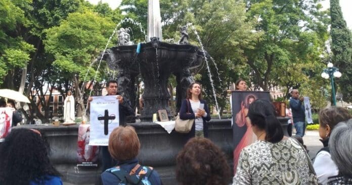 Católicos de Puebla fueron captados rezando el rosario en el zócalo de la ciudad en protesta por la inauguración de los Juegos Olímpicos.