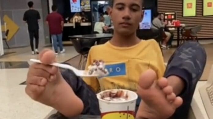 Mujer regaña a joven por comer con los pies