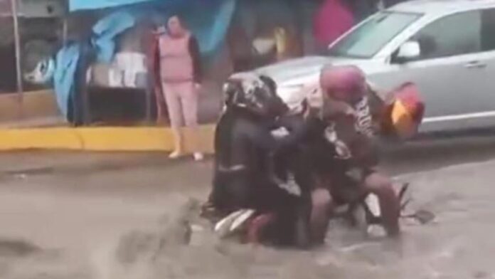 Video: Familia que viajaba en moto es arrastrada por la corriente tras fuertes lluvias en Ecatepec, Edomex