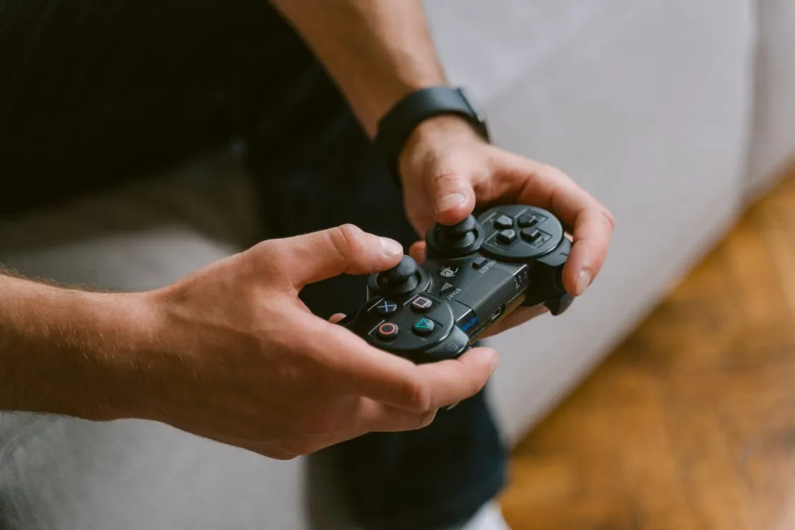 Manos sosteniendo un control de videojuegos durante una partida