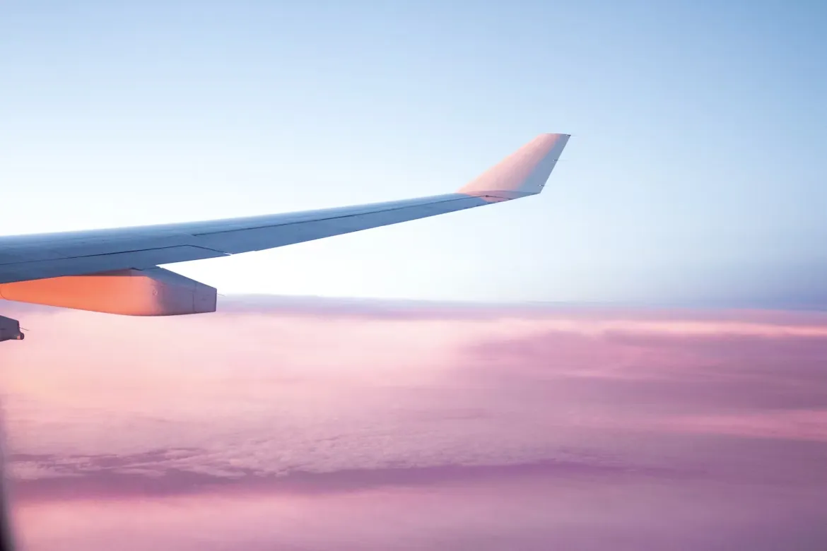 Ala de un avión sobre las nubes al atardecer