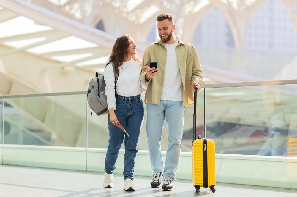 Pareja con maleta camina por la terminal de un aeropuerto