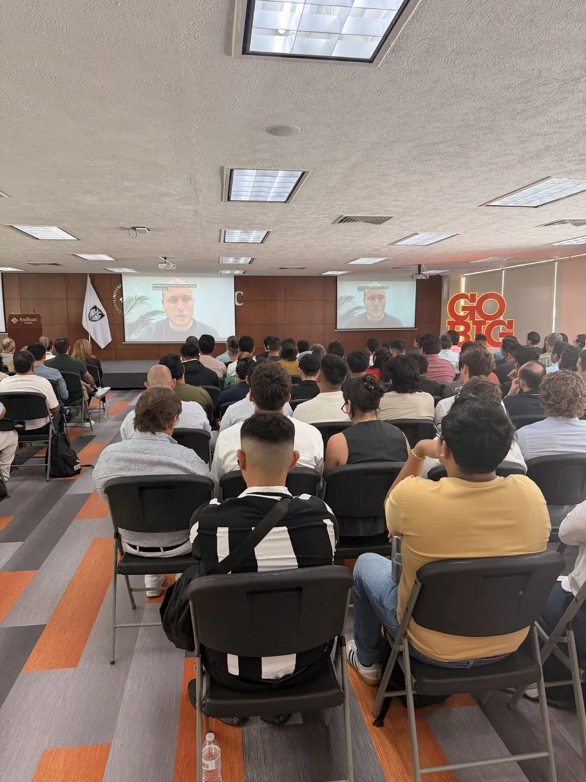 Sesión virtual con el equipo de Anthropic proyectada en las pantallas del auditorio