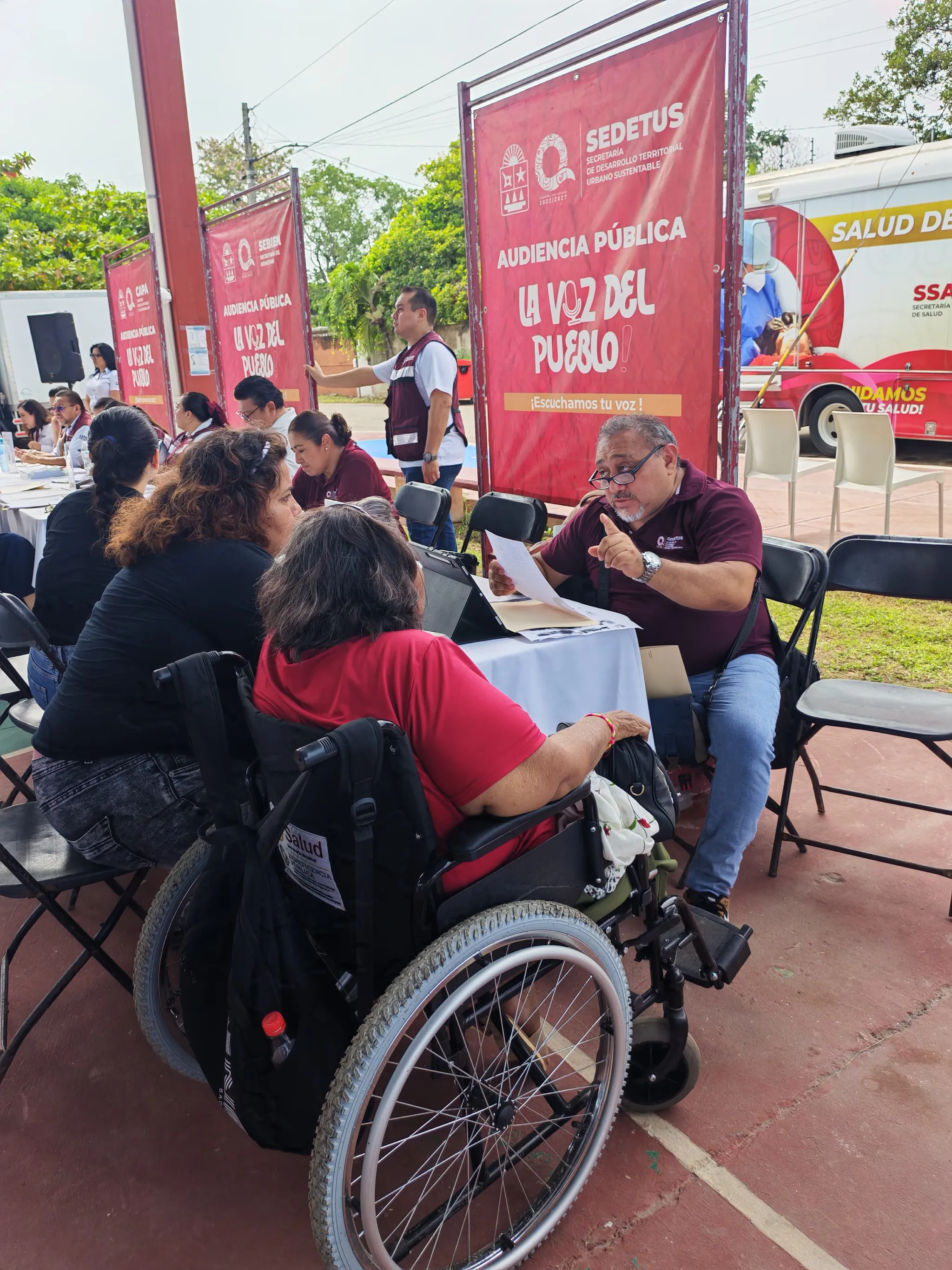 Personal de SEDETUS atiende a una ciudadana en silla de ruedas durante la audiencia pública «La Voz del Pueblo» en Calderitas